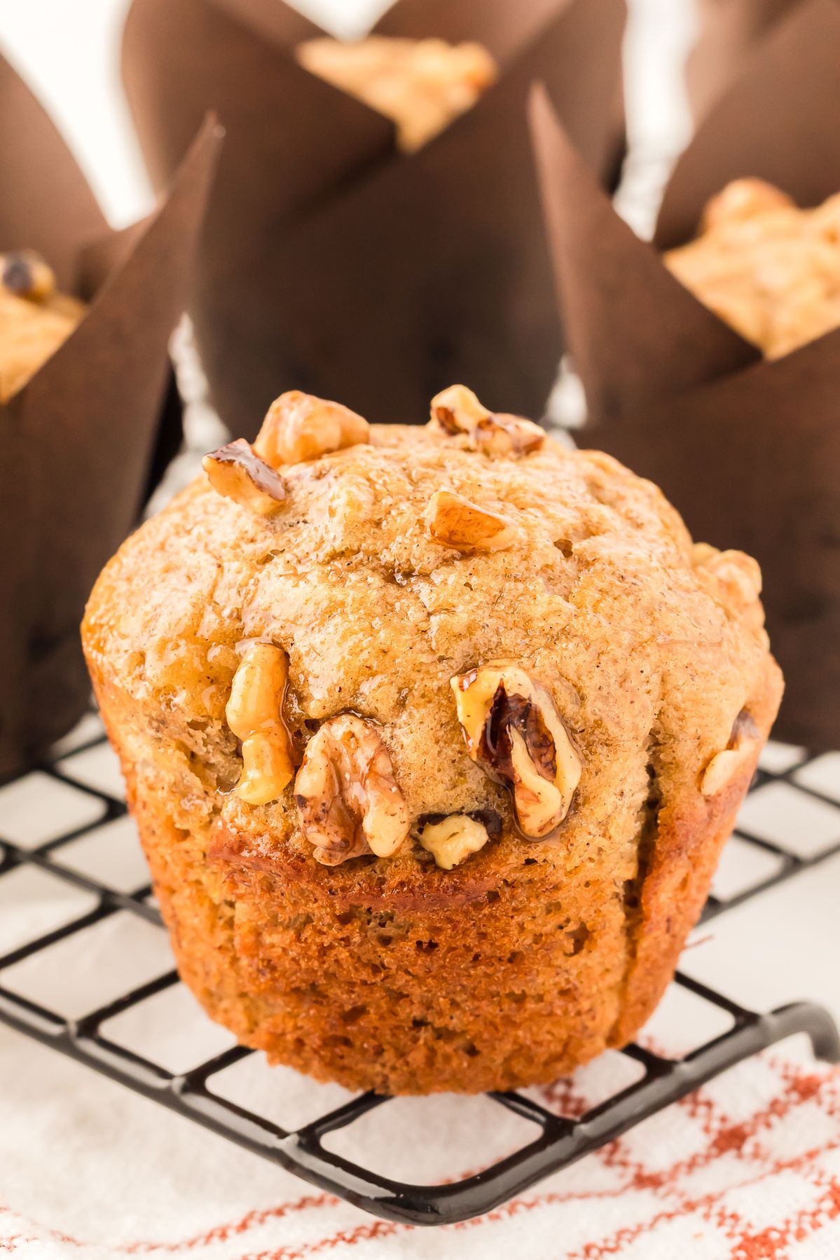 Banana bread muffin with a walnut topping on a cooling rack