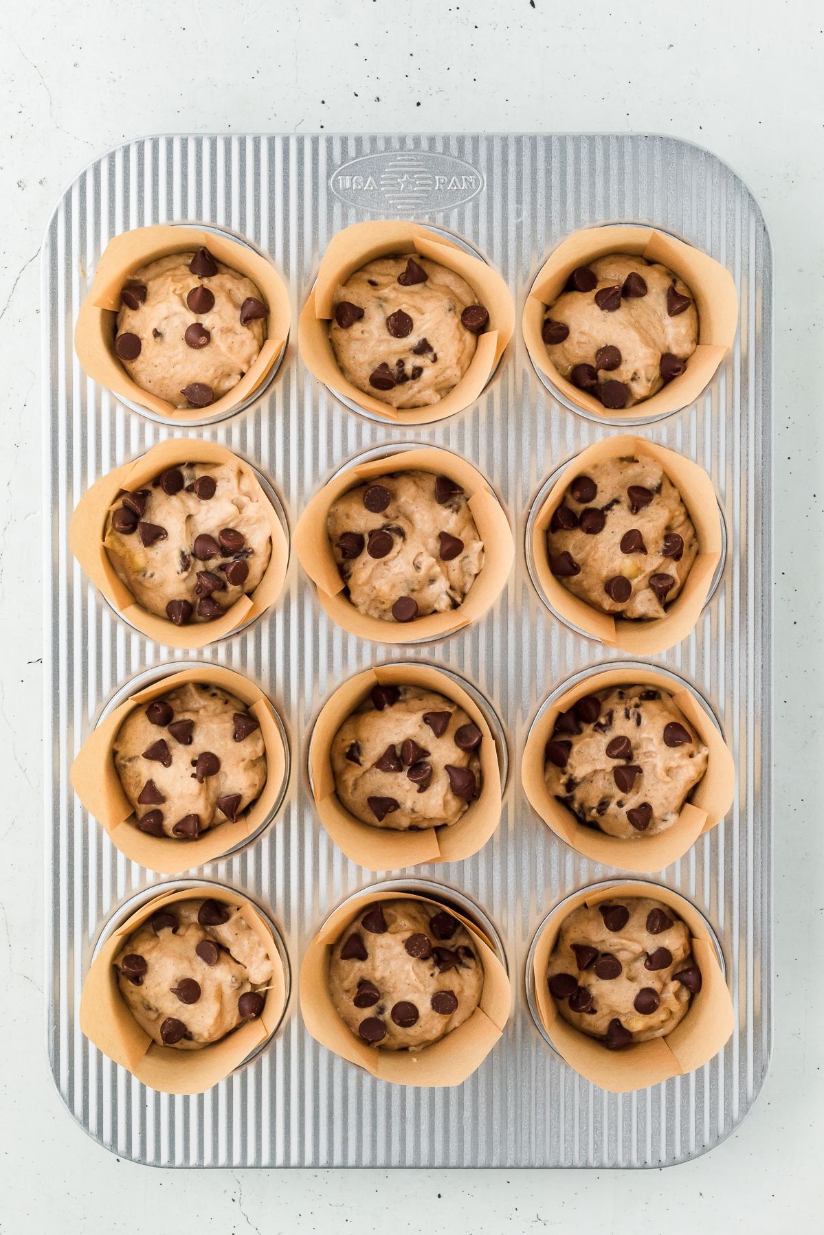 Banana chocolate chip muffin batter in parchment liners