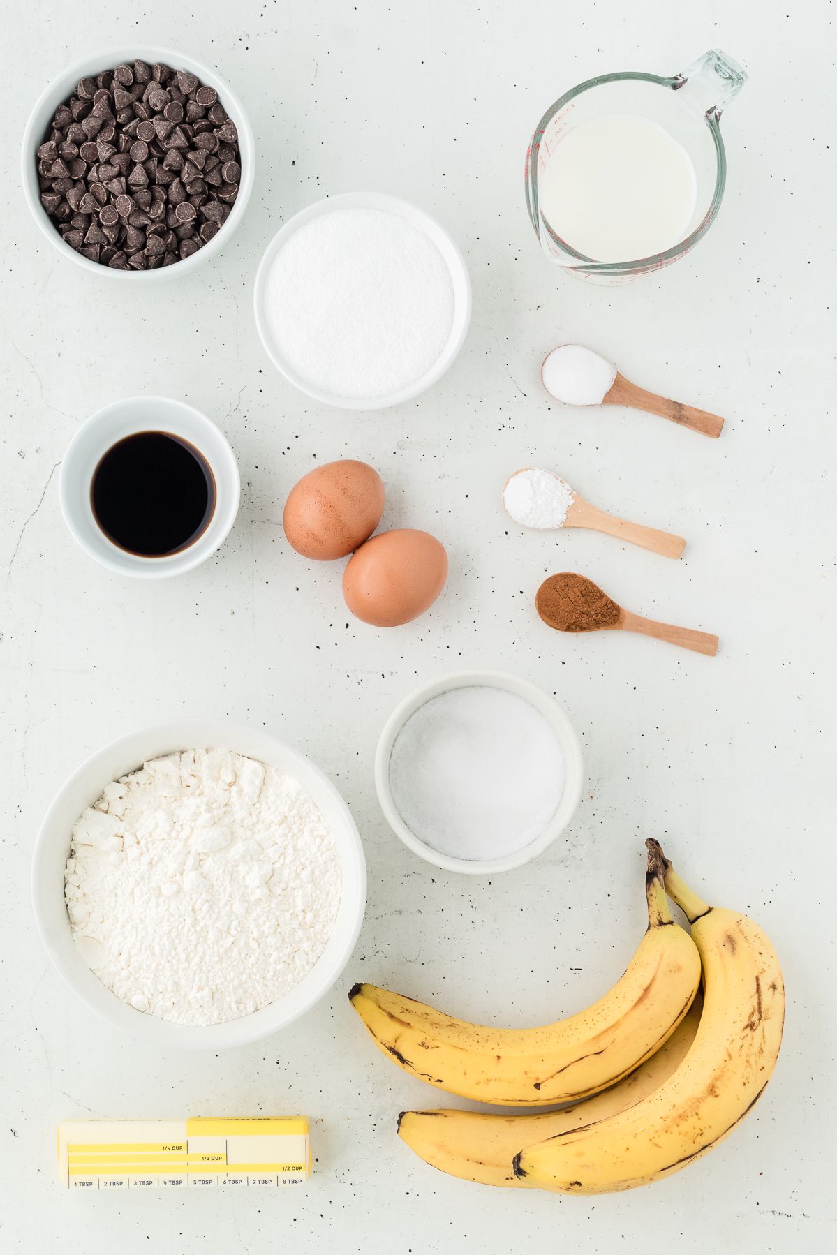 Ingredients for banana chocolate chip muffins: ripe bananas, chocolate chips, flour, sugar, butter, milk and eggs