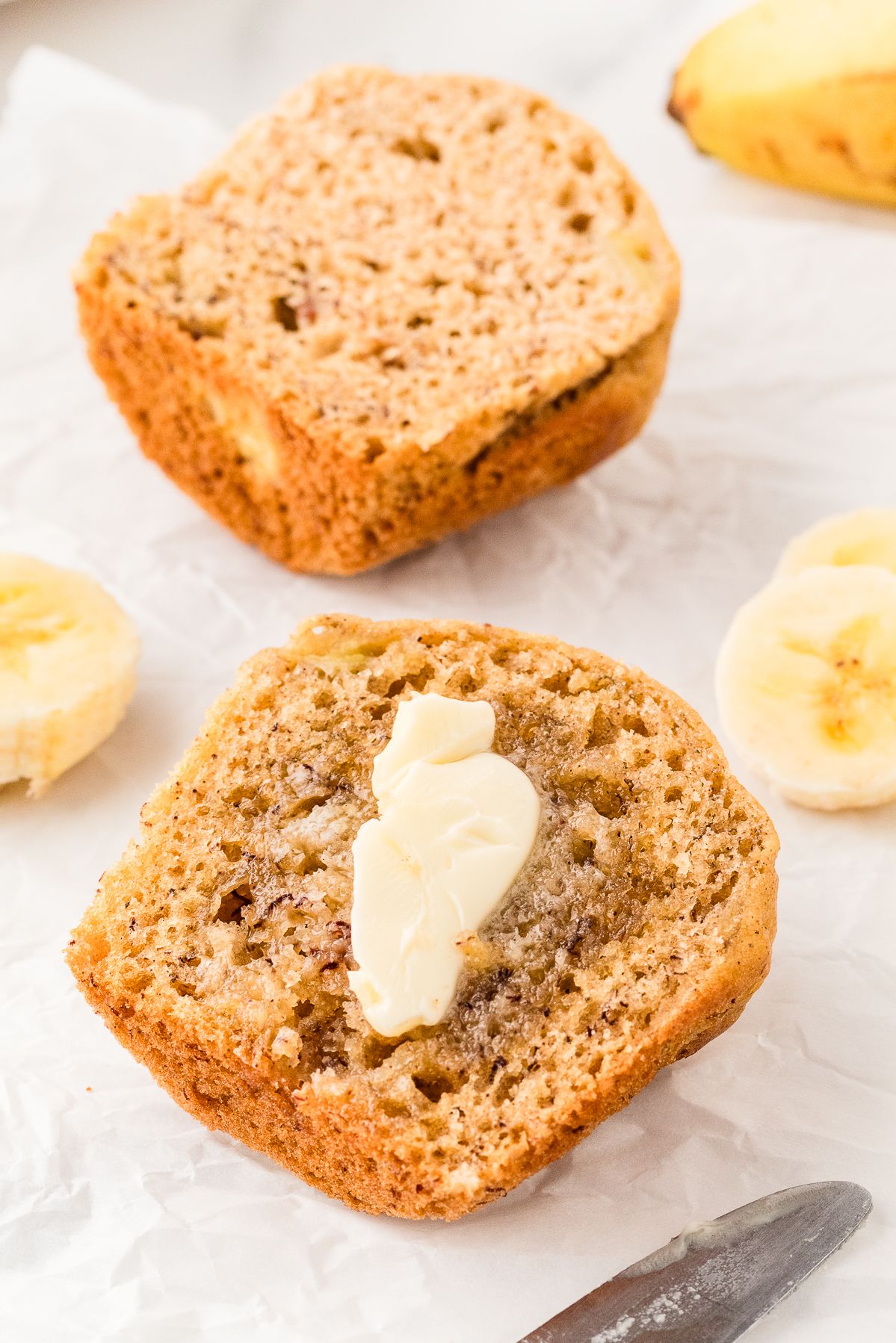 Banana muffin split in half and spread with butter