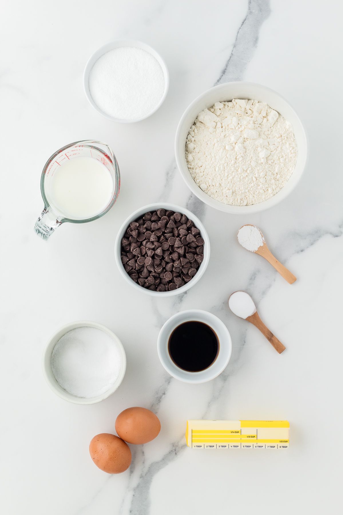 Ingredients for chocolate chip muffins: flour, sugar, milk, butter, eggs, vanilla and chocolate chips