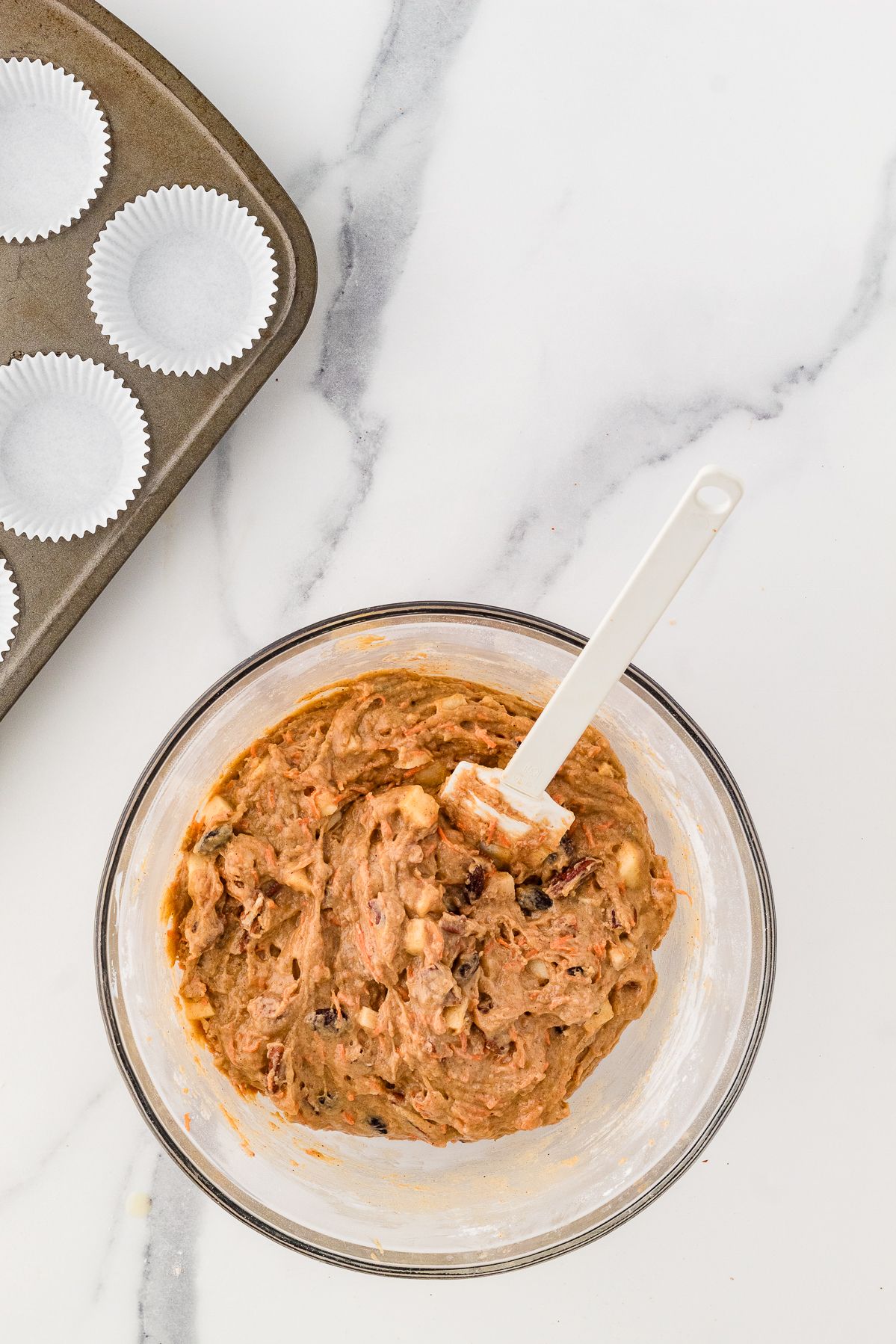 Gluten free morning glory muffin batter in a glass bowl