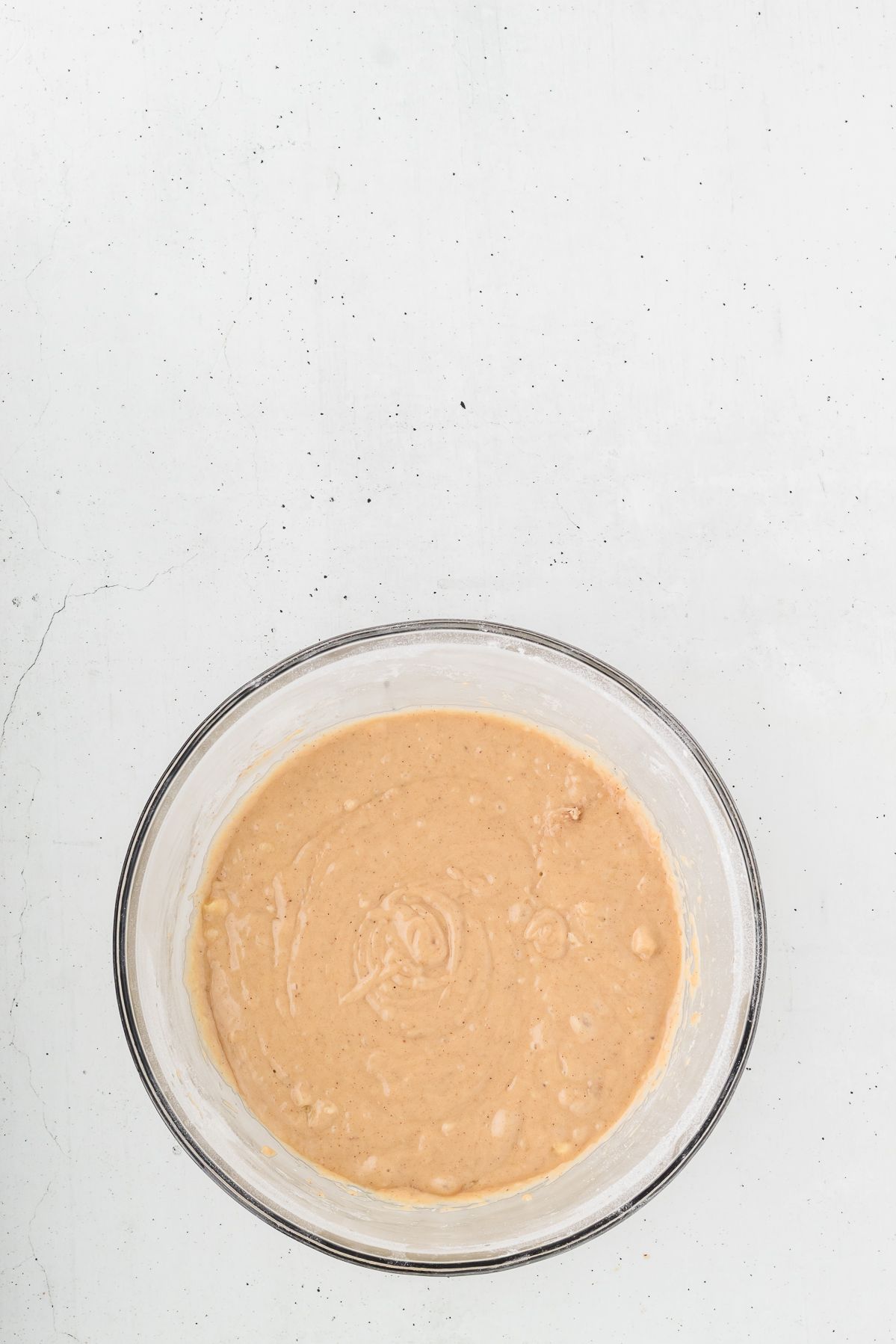 Healthy banana muffin batter in a glass bowl