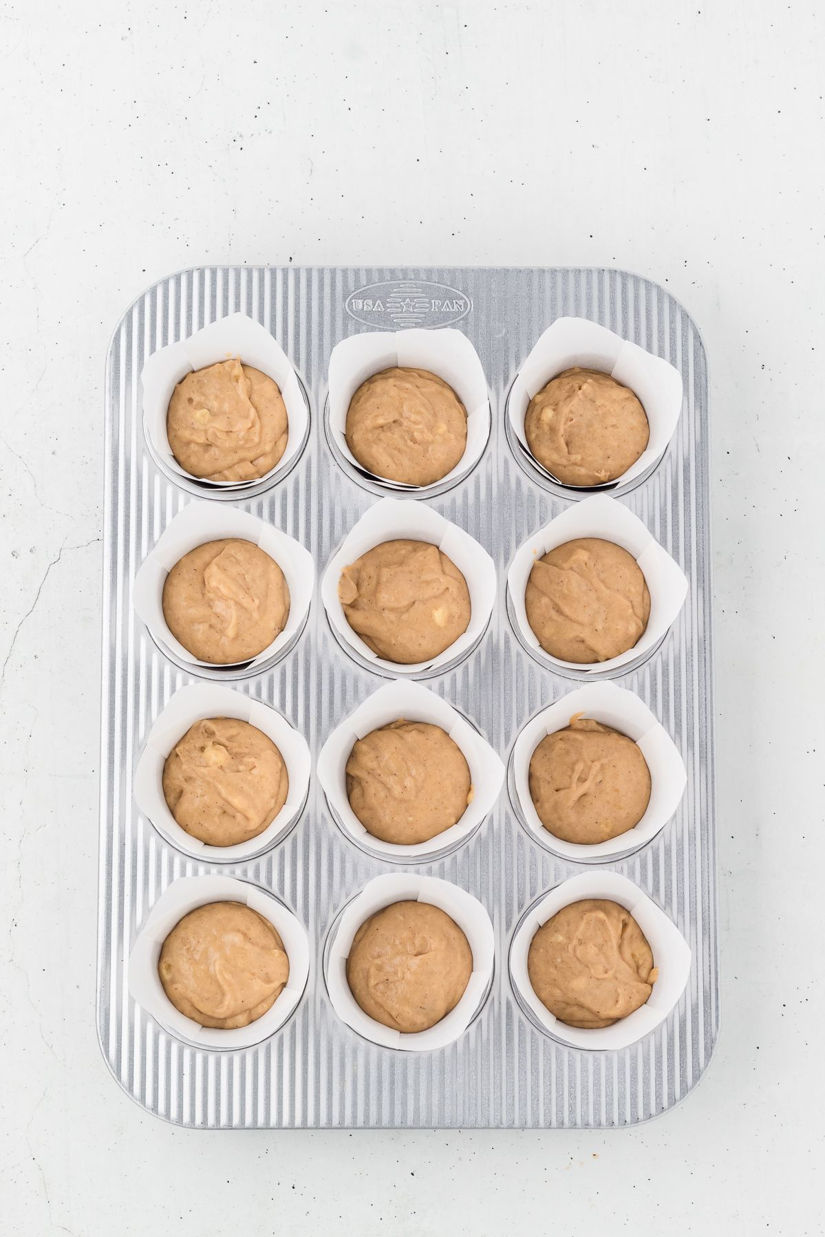Healthy banana muffin batter in a lined muffin tin