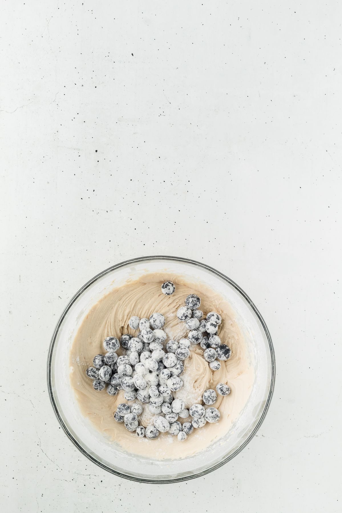 Flour coated blueberries added to healthy muffin batter