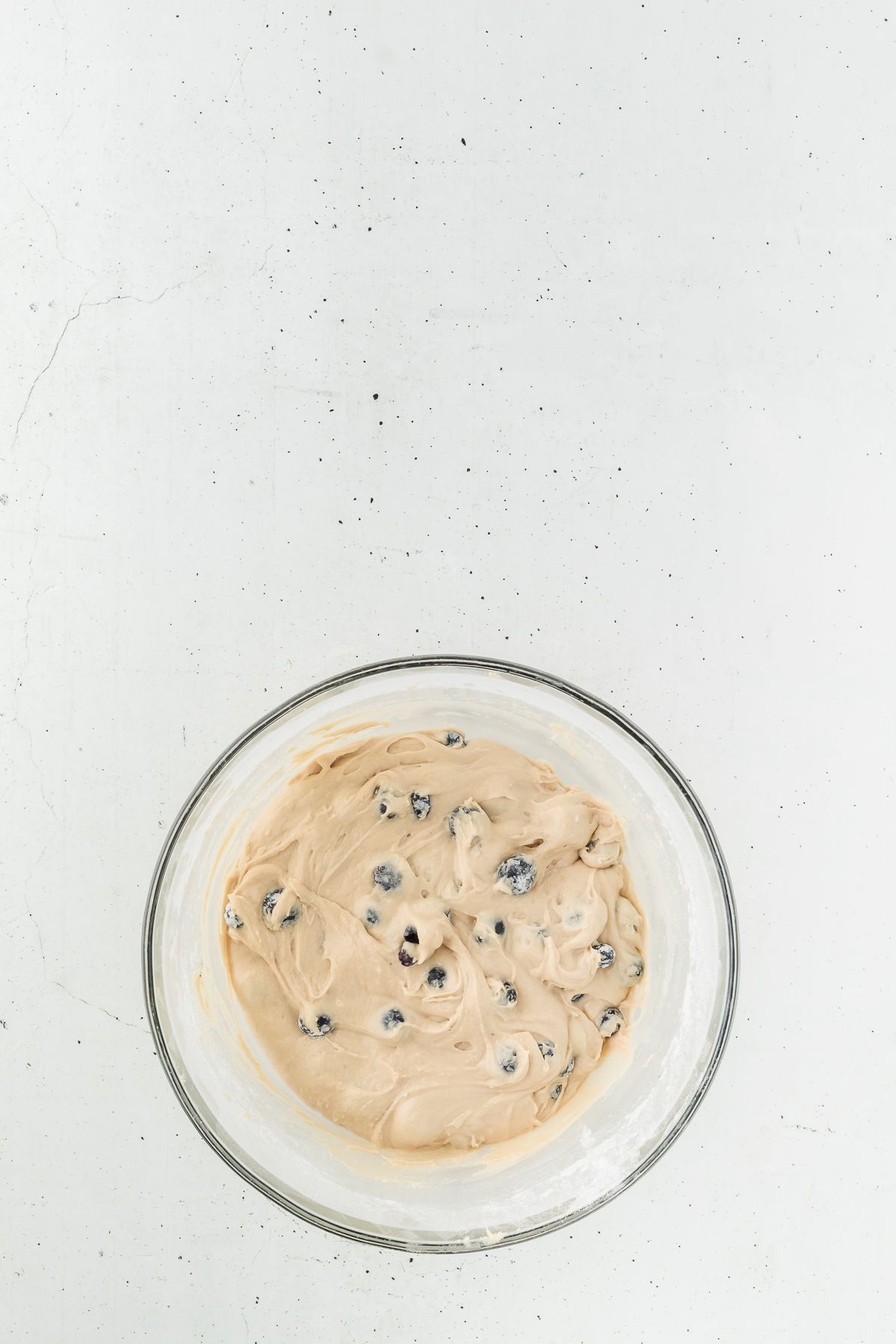 Healthy blueberry muffin batter in a glass bowl