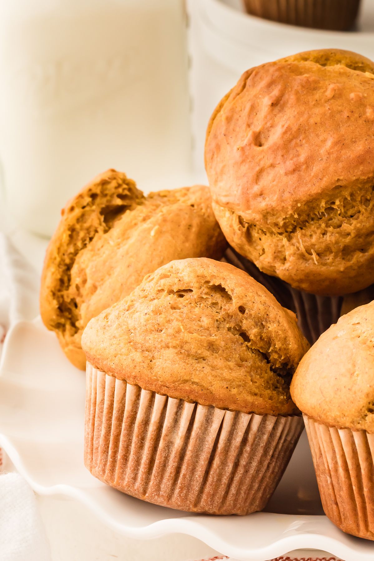 Healthy pumpkin muffins piled on a white cake stand