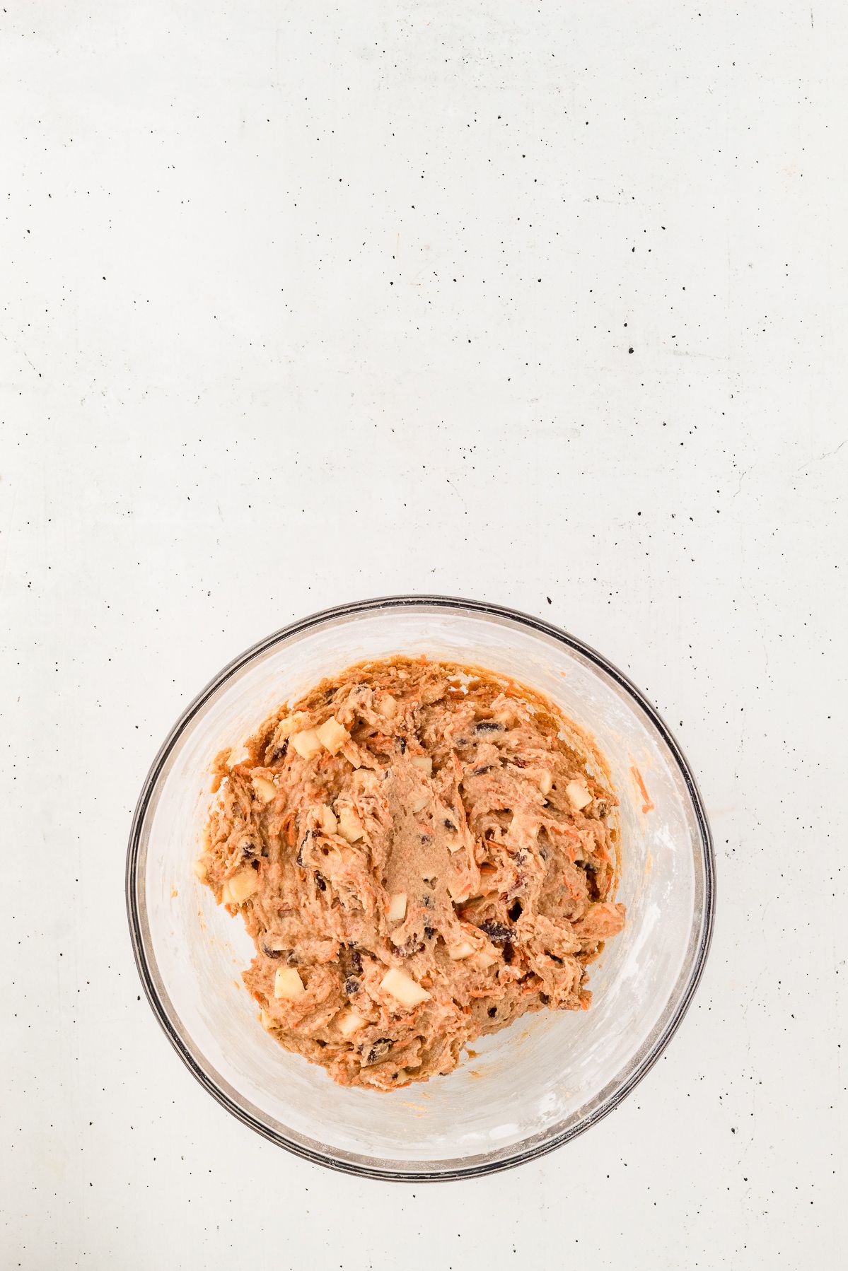 Thick morning glory muffin batter in a glass bowl