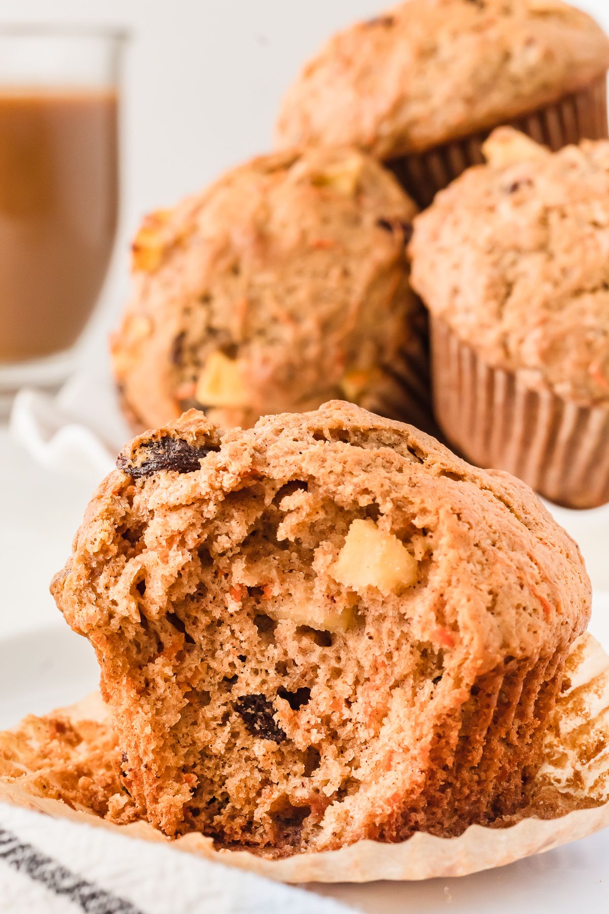 Morning glory muffin with a bite taken out showing carrot, apple and raisins