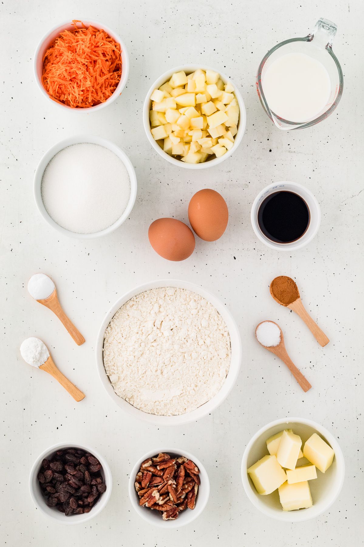 Ingredients for morning glory muffins: shredded carrots, apple, raisins, pecans, flour, eggs and spices
