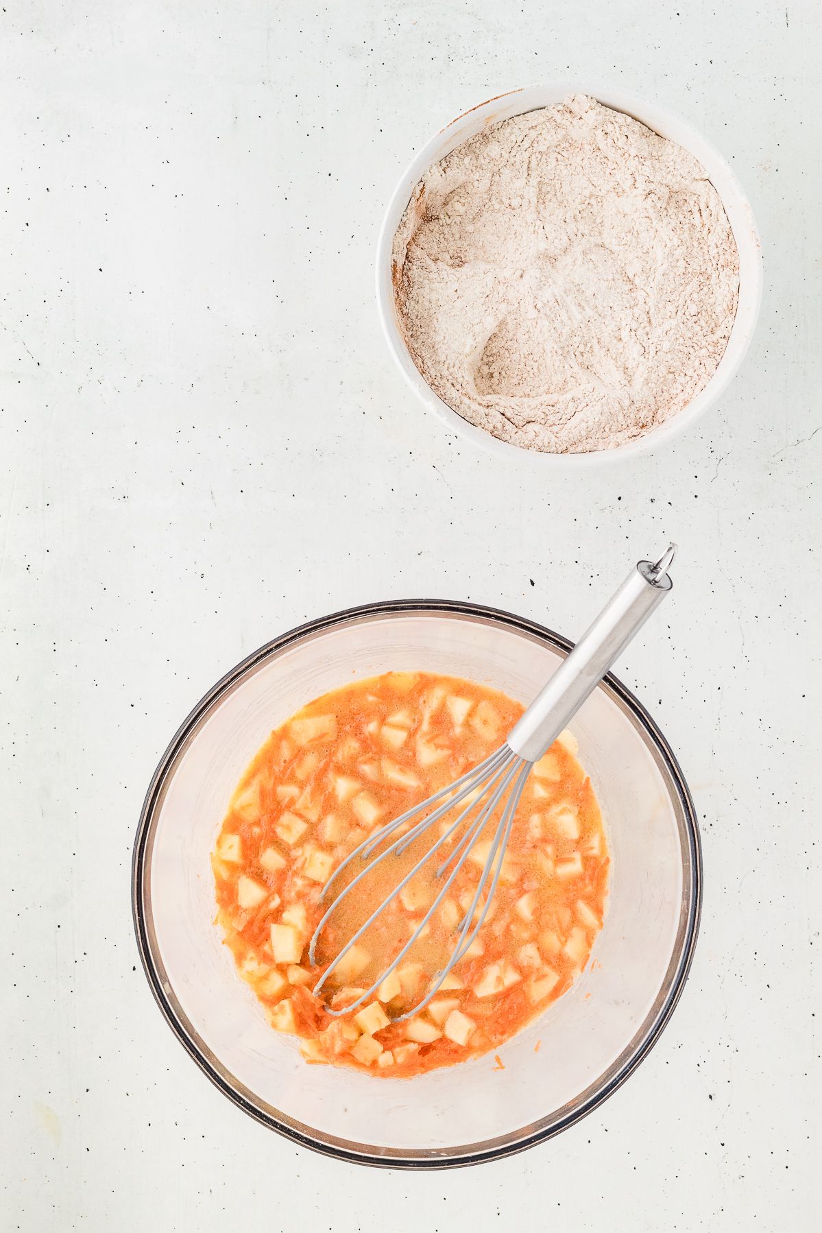 Whisking the wet ingredients with shredded carrot and apple for morning glory muffins