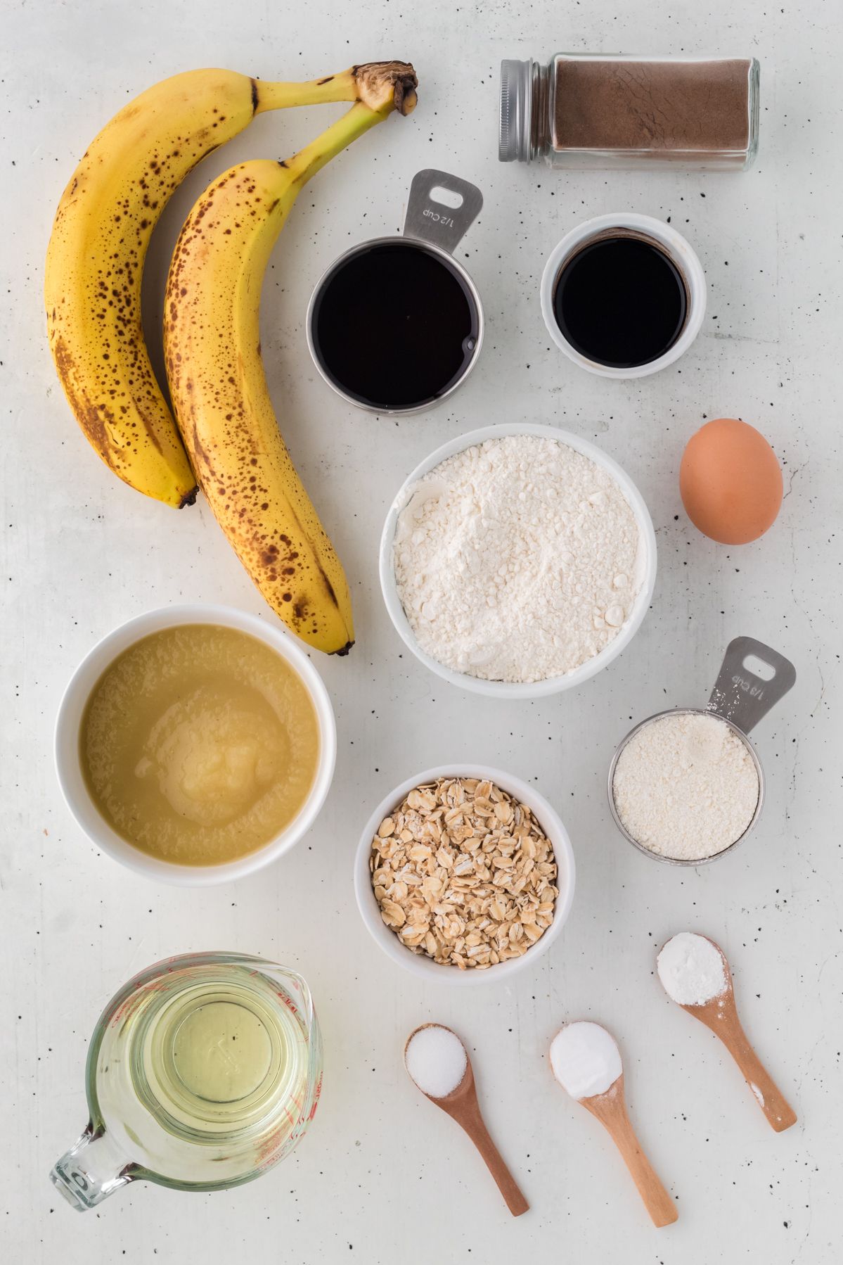 Ingredients for banana oatmeal muffins: ripe bananas, rolled oats, applesauce, flour, maple syrup and cinnamon