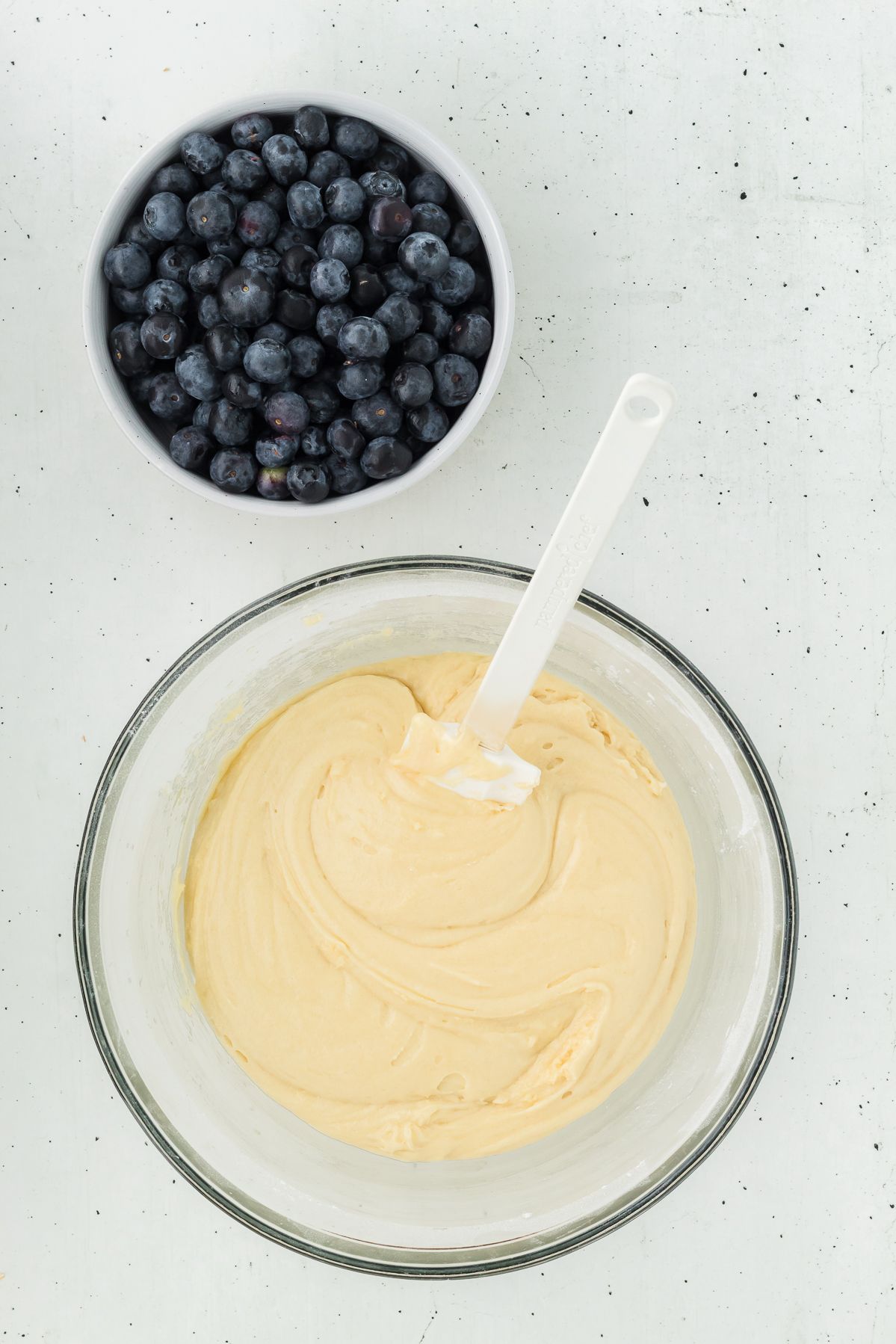 Lemon muffin batter in a glass mixing bowl
