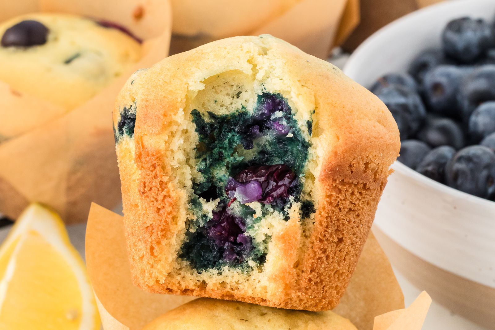 Lemon blueberry muffin with a bite taken out showing juicy blueberries